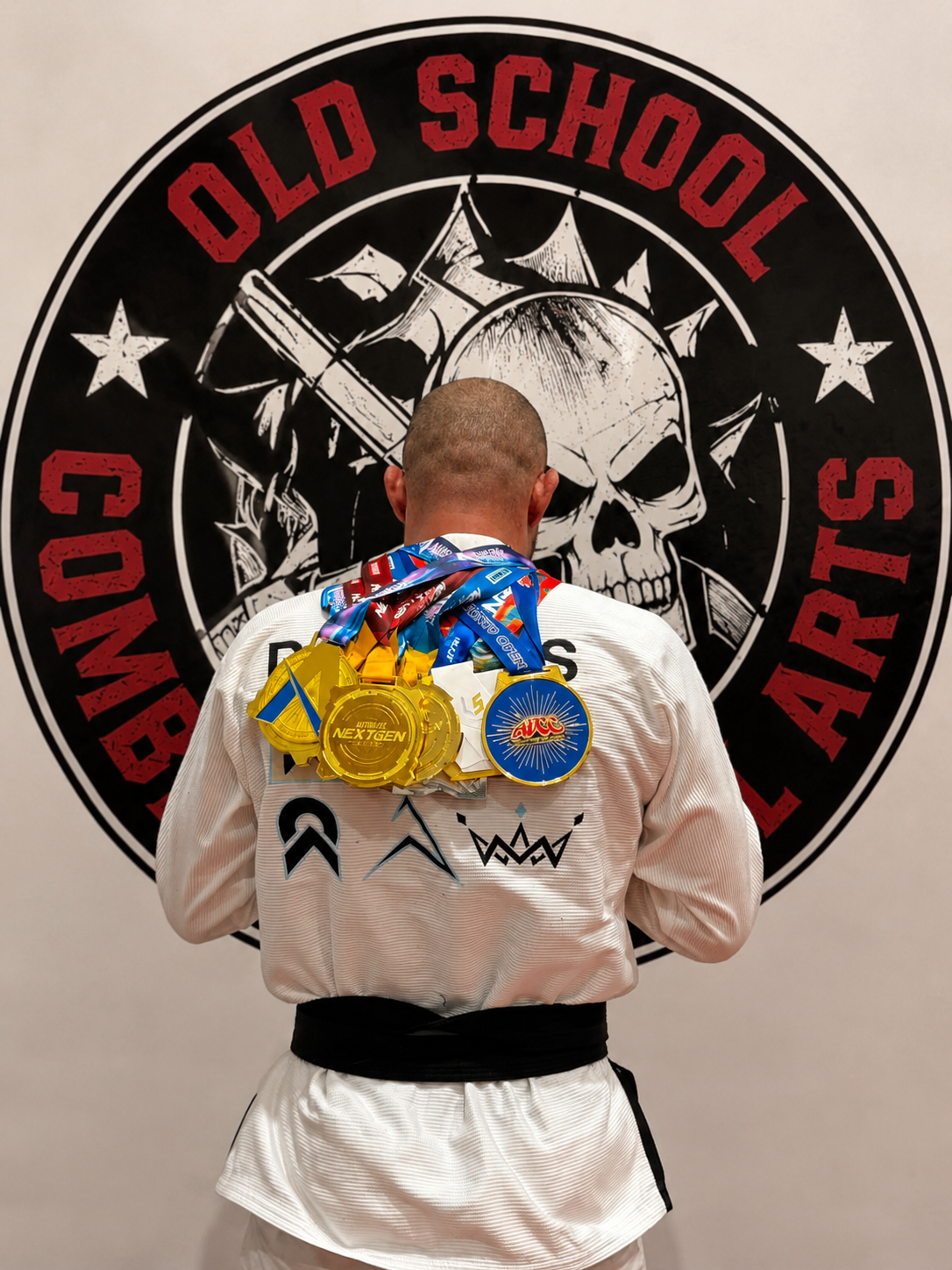 Professor Diego Santos showing the competition medals across the back of his uniform