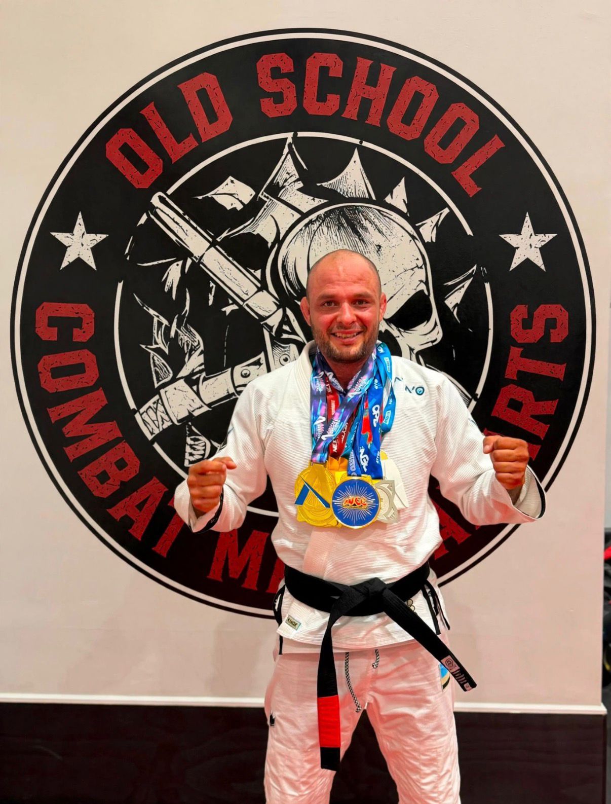 Professor Diego Santos wearing his Brazilian Jiu-Jitsu black belt and competition medals